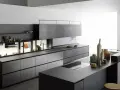 Cucina moderna con isola centrale, pensili a scomparsa e finiture in pietra. Un esempio di come progettare una cucina funzionale ed elegante.