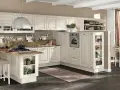 Accogliente cucina stile nordico con isola centrale, mobili chiari e dettagli in legno. Un ambiente luminoso e funzionale.