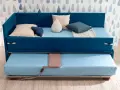 Camera studio con divano letto blu, con un secondo letto estraibile sotto. Perfetto per ospitare amici o per un riposino.