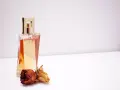 Elegante flacone di profumo dorato con rose secche, un'ispirazione su come scegliere un profumo che ti rappresenti.