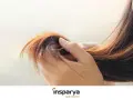 Mano che accarezza capelli sottili e diradati, mostrando la loro fragilità.