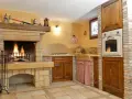 Accoglienti cucine di campagna con camino acceso, mobili in legno scuro e dettagli rustici. Un angolo cottura funzionale e un'atmosfera calda e invitante.