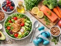 Dieta sana e allenamento per perdere peso in una settimana: insalata con pollo, salmone, verdure, frutta e pesi.