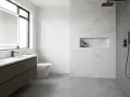 Bagno moderno con doppio lavabo, specchio illuminato, WC e doccia a filo pavimento. Ideale per capire come pulire la doccia e mantenere tutto splendente.