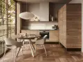 Cucina moderna con mobili in legno di noce e un tavolo rotondo, perfetta per arredare la cucina in modo originale.