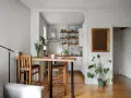 Soggiorno e cucina in stile nordico, con tavolo in legno e sgabelli, un tocco di stile scandinavo.