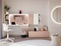Un moderno angolo trucco in camera da letto con scrivania, specchio rotondo illuminato e accessori.