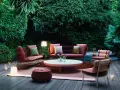 Un terrazzo accogliente con mobili da esterno color corallo e illuminazione soffusa, ideale per godersi la sera.