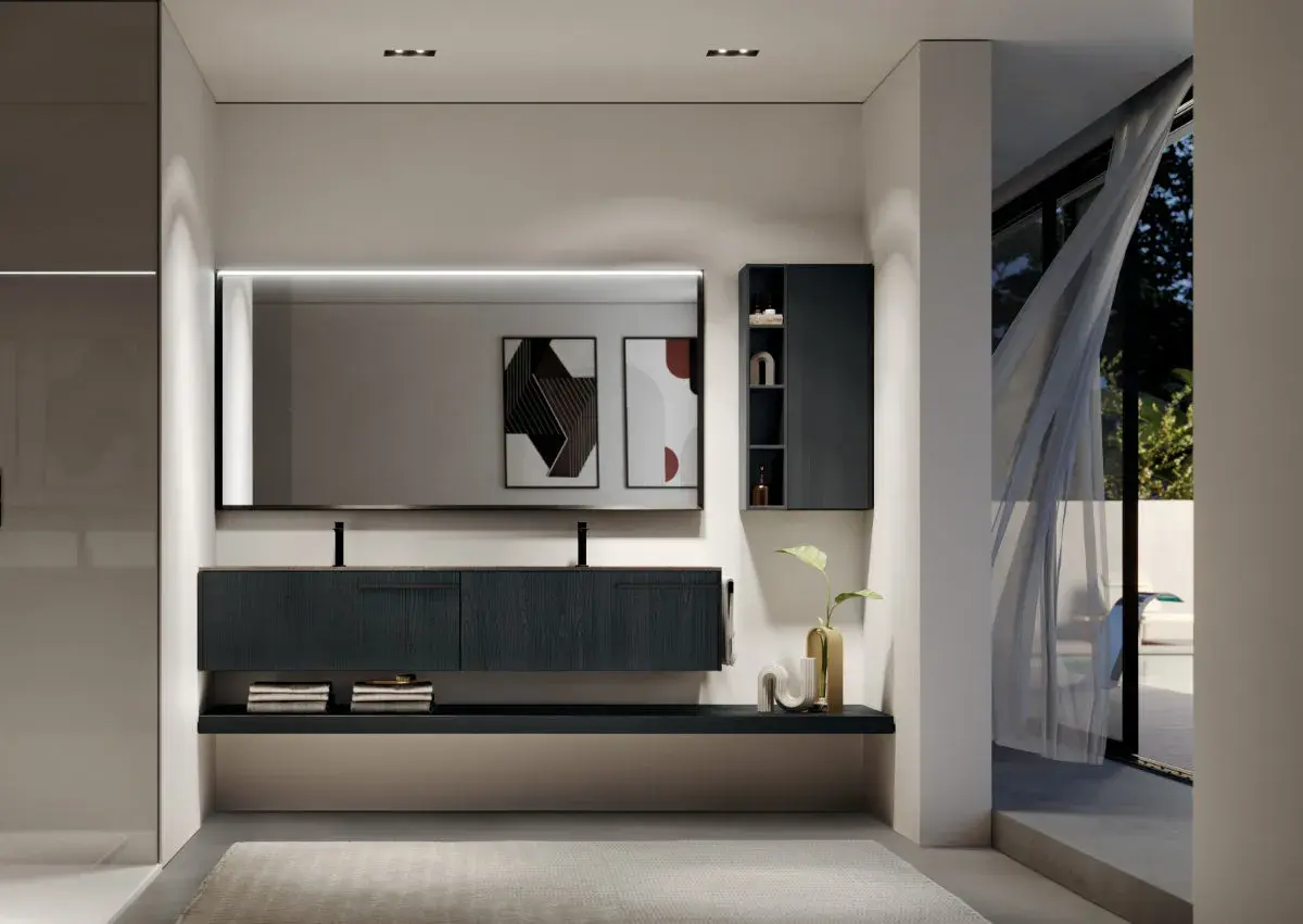Elegante bagno moderno con mobile sospeso scuro, specchio illuminato e vista su un giardino esterno.
