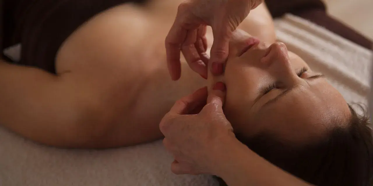 Mani esperte eseguono un massaggio viso lifting, modellando i contorni per un aspetto più giovane e radioso.