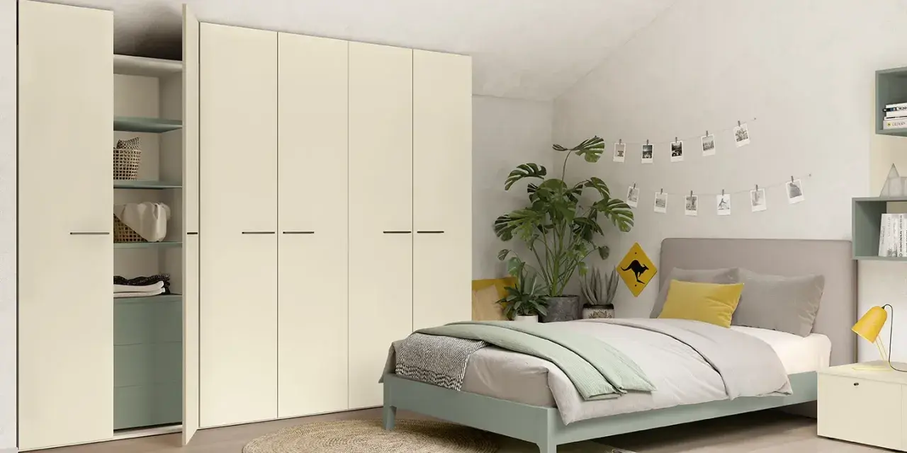 Camera da letto moderna con letto una piazza e mezza, armadio bianco e piante verdi.