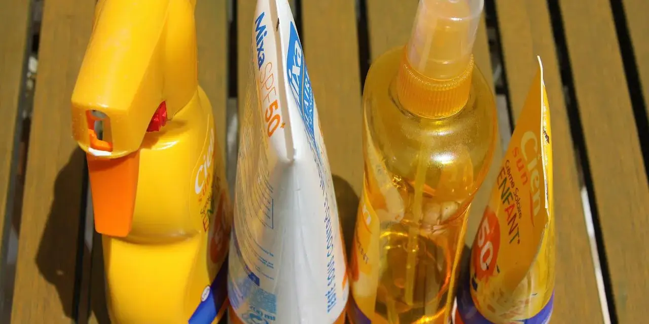 Prodotti solari scaduti, tra cui una crema Mixa SPF50 e spray Cien, pronti per essere smaltiti. Dove si buttano le creme corpo scadute?