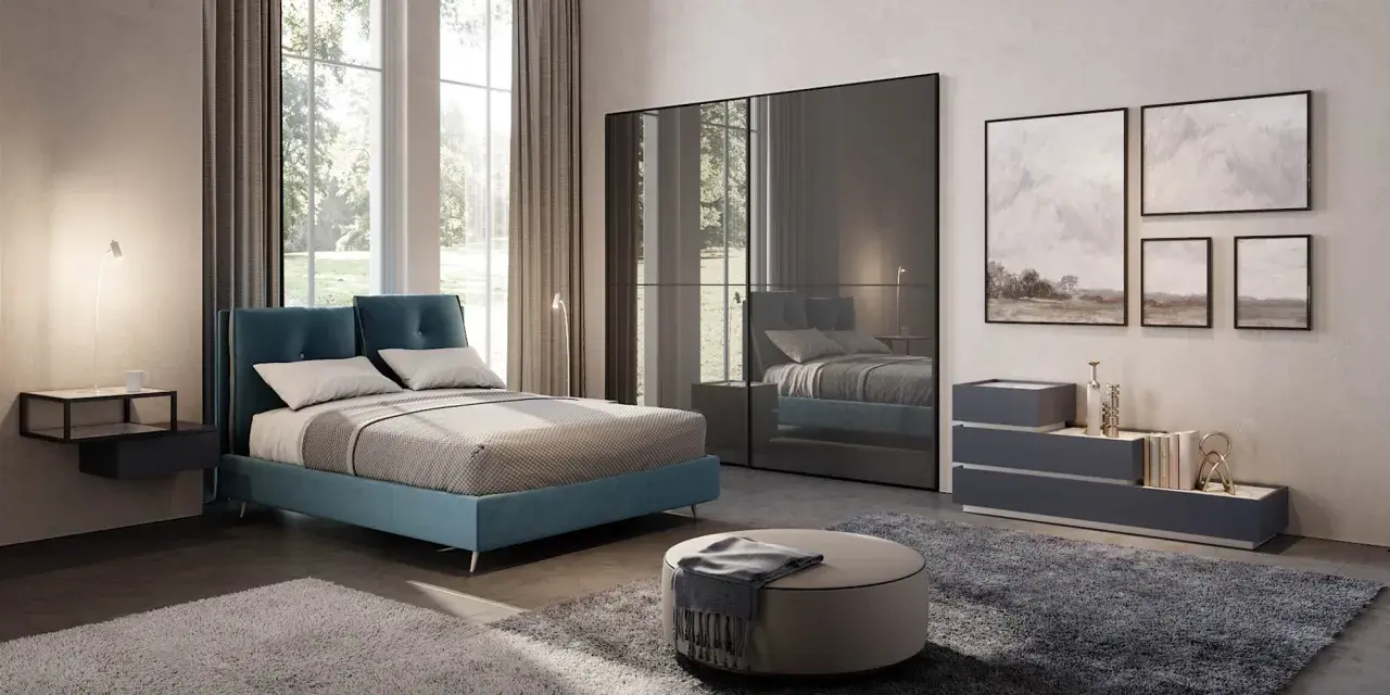 Un letto blu moderno, un armadio a specchio e quadri paesaggistici creano camere da letto da sogno.