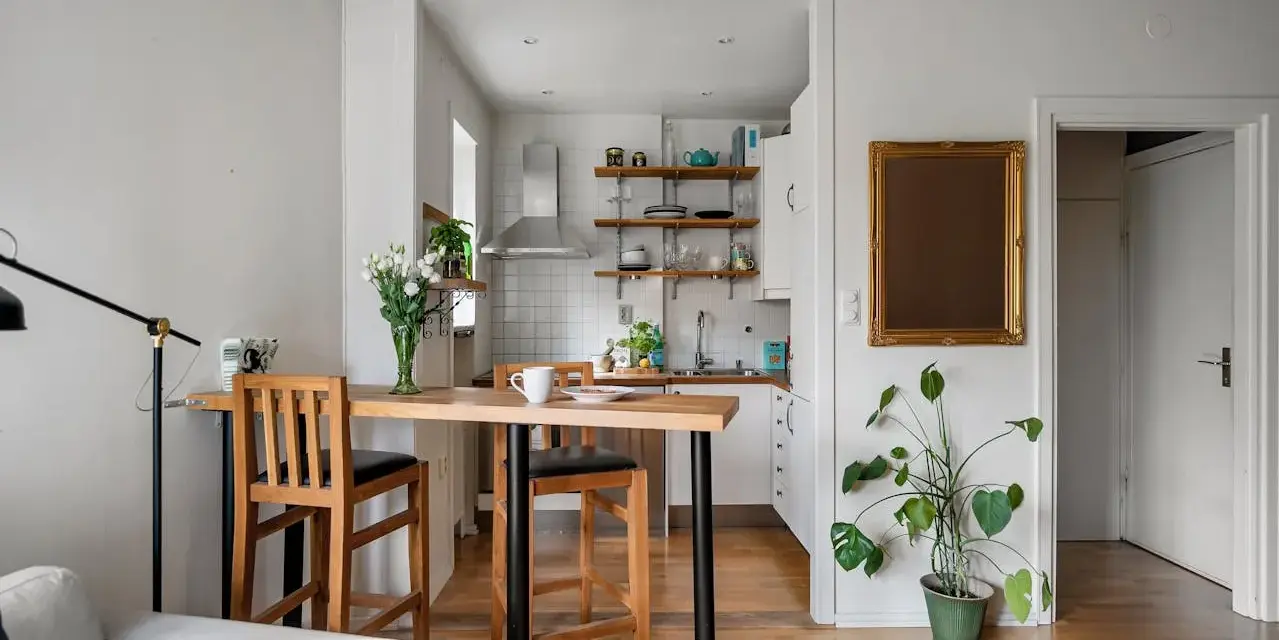 Soggiorno e cucina in stile nordico, con tavolo in legno e sgabelli, un tocco di stile scandinavo.