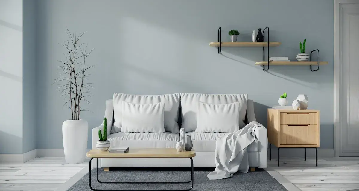 Soggiorno moderno con divano bianco, tavolino in legno e pareti color carta da zucchero.