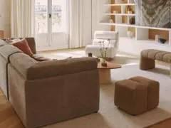 Soggiorno con divano componibile, poltrona, pouf e panca. Arredamento casa stile moderno con mobili in legno e tessuti neutri.