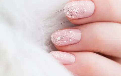 Unghie natalizie rosa pastello con brillantini scintillanti e decorazioni a stella, su sfondo bianco soffice.