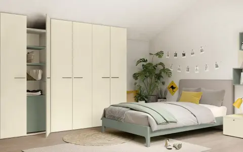 Camera da letto moderna con letto una piazza e mezza, armadio bianco e piante verdi.