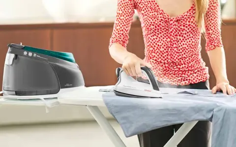 Donna stira una camicia con un ferro a vapore. Scopri come pulire il ferro da stiro dal calcare interno per risultati perfetti.