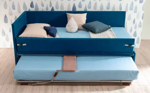 Camera studio con divano letto blu, con un secondo letto estraibile sotto. Perfetto per ospitare amici o per un riposino.