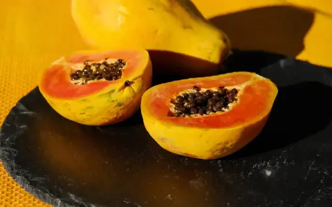 Papaya tagliata a metà, con i suoi semi neri visibili. Un frutto noto per il suo aiuto all'intestino.