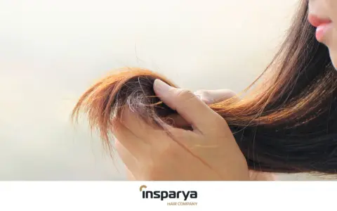 Mano che accarezza capelli sottili e diradati, mostrando la loro fragilità.