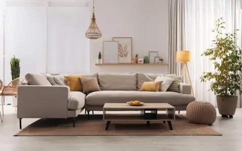 Divano angolare in un accogliente soggiorno, con cuscini decorativi e un tavolino. Il colore taupe del divano crea un'atmosfera rilassante.
