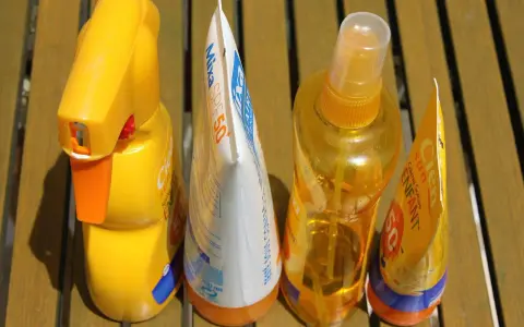 Prodotti solari scaduti, tra cui una crema Mixa SPF50 e spray Cien, pronti per essere smaltiti. Dove si buttano le creme corpo scadute?