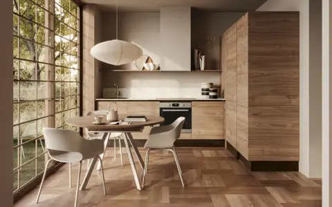 Cucina moderna con mobili in legno di noce e un tavolo rotondo, perfetta per arredare la cucina in modo originale.