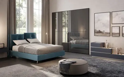 Un letto blu moderno, un armadio a specchio e quadri paesaggistici creano camere da letto da sogno.