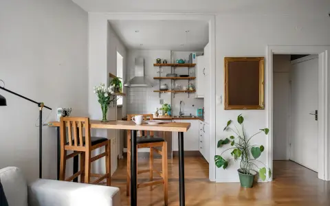 Soggiorno e cucina in stile nordico, con tavolo in legno e sgabelli, un tocco di stile scandinavo.