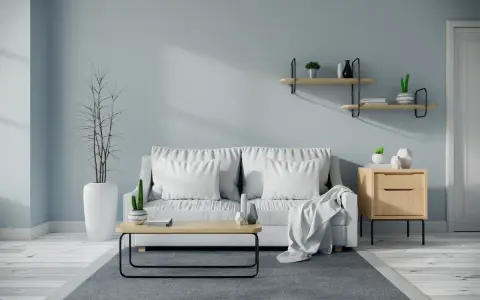 Soggiorno moderno con divano bianco, tavolino in legno e pareti color carta da zucchero.
