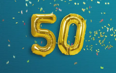 Palloncini dorati a forma di 50 su sfondo blu con coriandoli. Un'immagine perfetta per frasi profonde compleanno 50 anni.