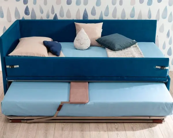 Camera studio con divano letto blu, con un secondo letto estraibile sotto. Perfetto per ospitare amici o per un riposino.