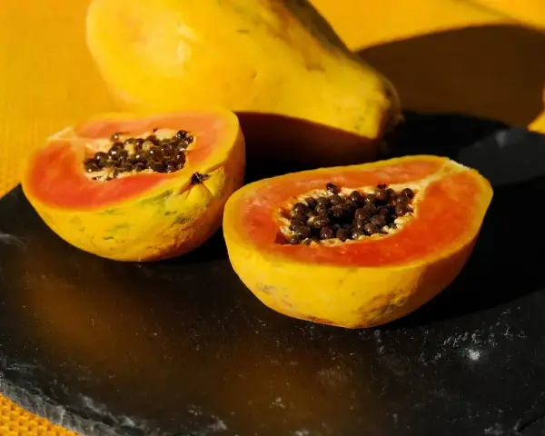 Papaya tagliata a metà, con i suoi semi neri visibili. Un frutto noto per il suo aiuto all'intestino.
