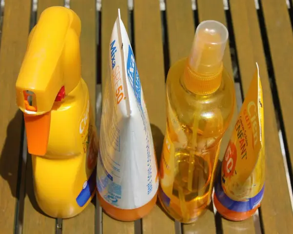 Prodotti solari scaduti, tra cui una crema Mixa SPF50 e spray Cien, pronti per essere smaltiti. Dove si buttano le creme corpo scadute?