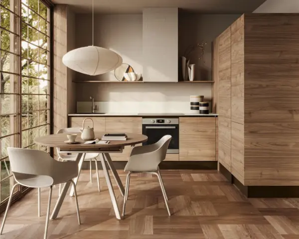 Cucina moderna con mobili in legno di noce e un tavolo rotondo, perfetta per arredare la cucina in modo originale.