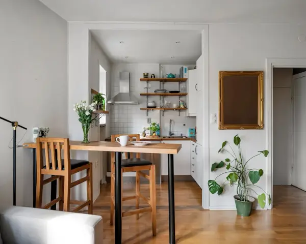 Soggiorno e cucina in stile nordico, con tavolo in legno e sgabelli, un tocco di stile scandinavo.