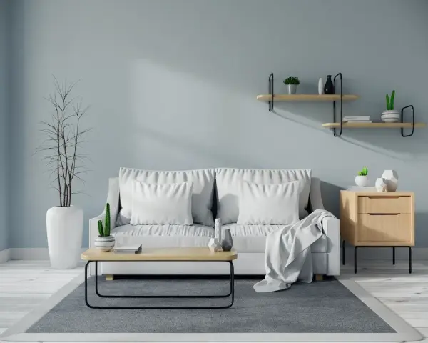 Soggiorno moderno con divano bianco, tavolino in legno e pareti color carta da zucchero.
