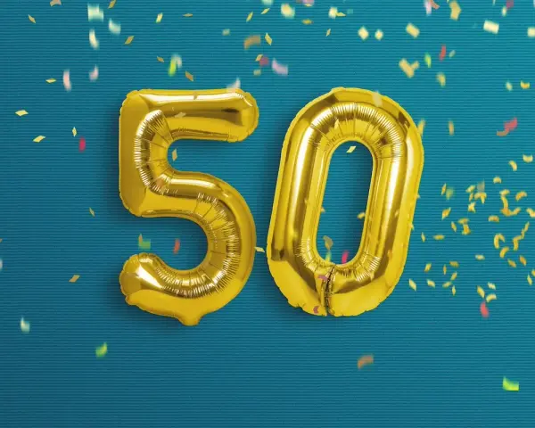 Palloncini dorati a forma di 50 su sfondo blu con coriandoli. Un'immagine perfetta per frasi profonde compleanno 50 anni.