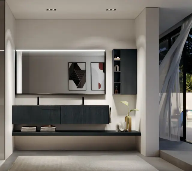 Elegante bagno moderno con mobile sospeso scuro, specchio illuminato e vista su un giardino esterno.