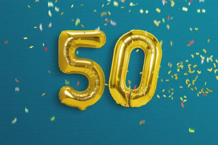 Palloncini dorati a forma di 50 su sfondo blu con coriandoli. Un'immagine perfetta per frasi profonde compleanno 50 anni.
