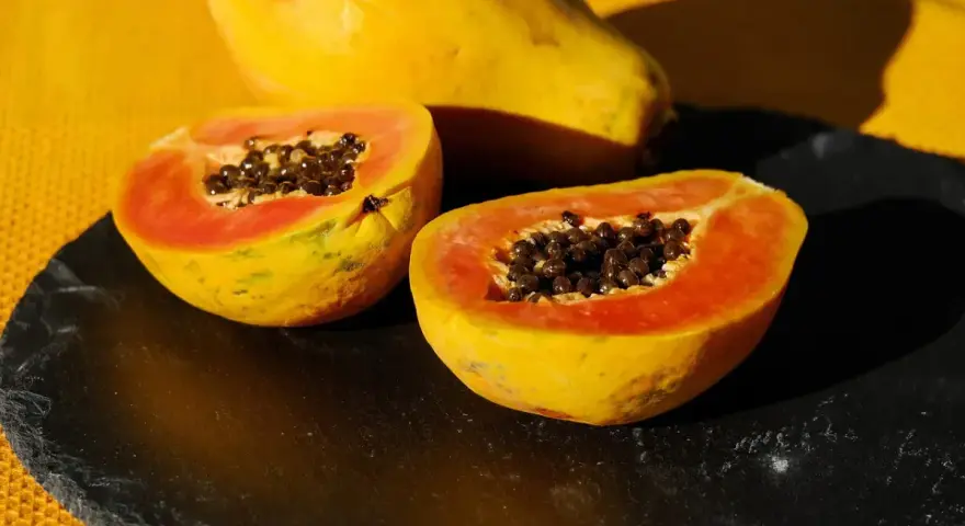 Papaya tagliata a metà, con i suoi semi neri visibili. Un frutto noto per il suo aiuto all'intestino.