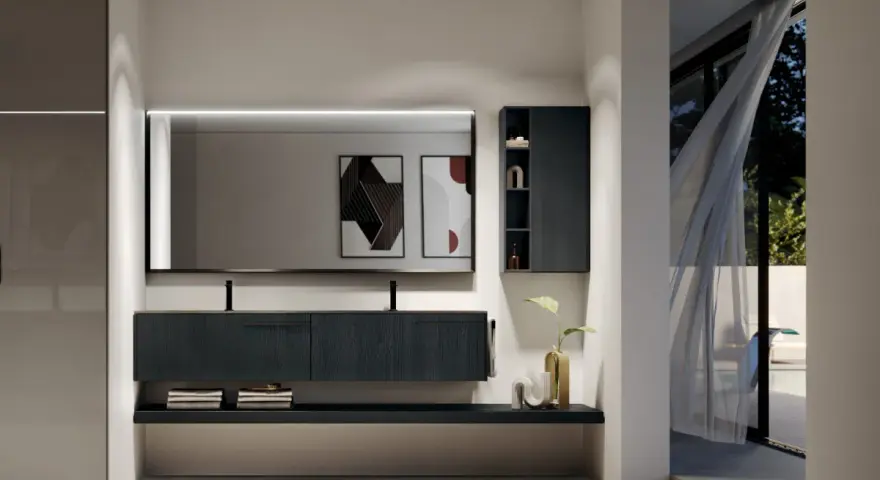 Elegante bagno moderno con mobile sospeso scuro, specchio illuminato e vista su un giardino esterno.