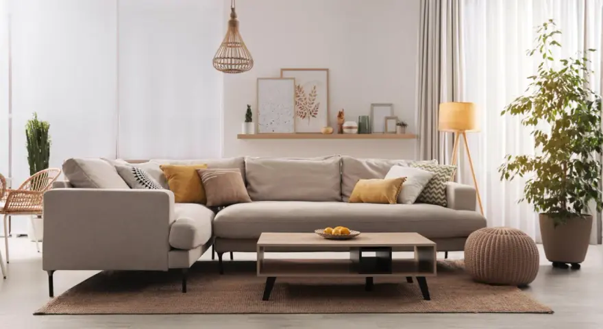 Divano angolare in un accogliente soggiorno, con cuscini decorativi e un tavolino. Il colore taupe del divano crea un'atmosfera rilassante.