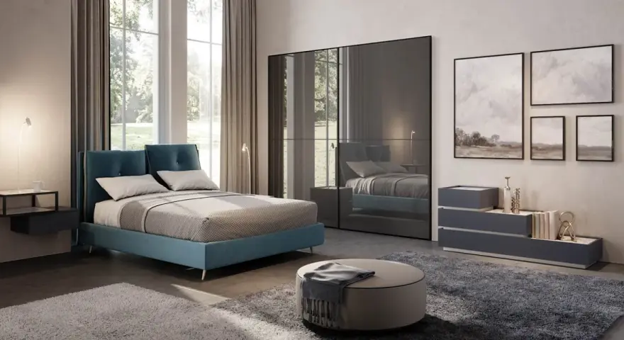 Un letto blu moderno, un armadio a specchio e quadri paesaggistici creano camere da letto da sogno.