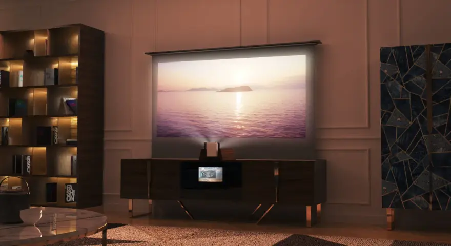 Mobile nascondi TV con proiettore integrato, schermo su cui scorre un tramonto sul mare, libreria e mobile decorato.