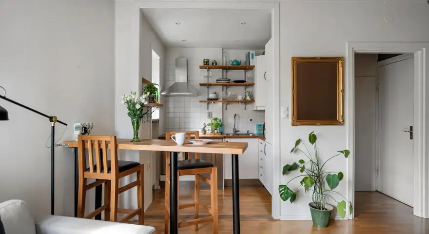 Soggiorno e cucina in stile nordico, con tavolo in legno e sgabelli, un tocco di stile scandinavo.