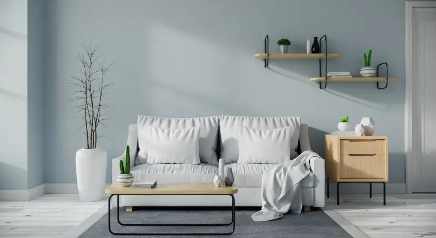 Soggiorno moderno con divano bianco, tavolino in legno e pareti color carta da zucchero.