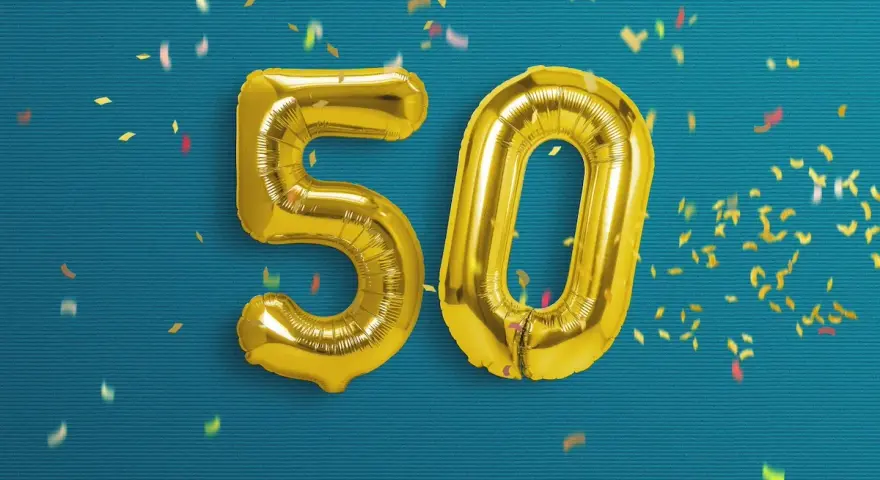 Palloncini dorati a forma di 50 su sfondo blu con coriandoli. Un'immagine perfetta per frasi profonde compleanno 50 anni.